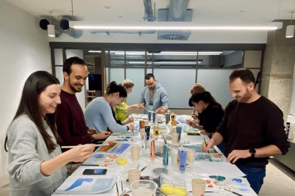 Team participating in pottery, painting, and creative art workshops